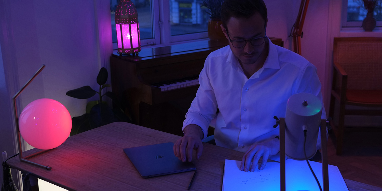 image of a person reading his notes in a purple-coloured light